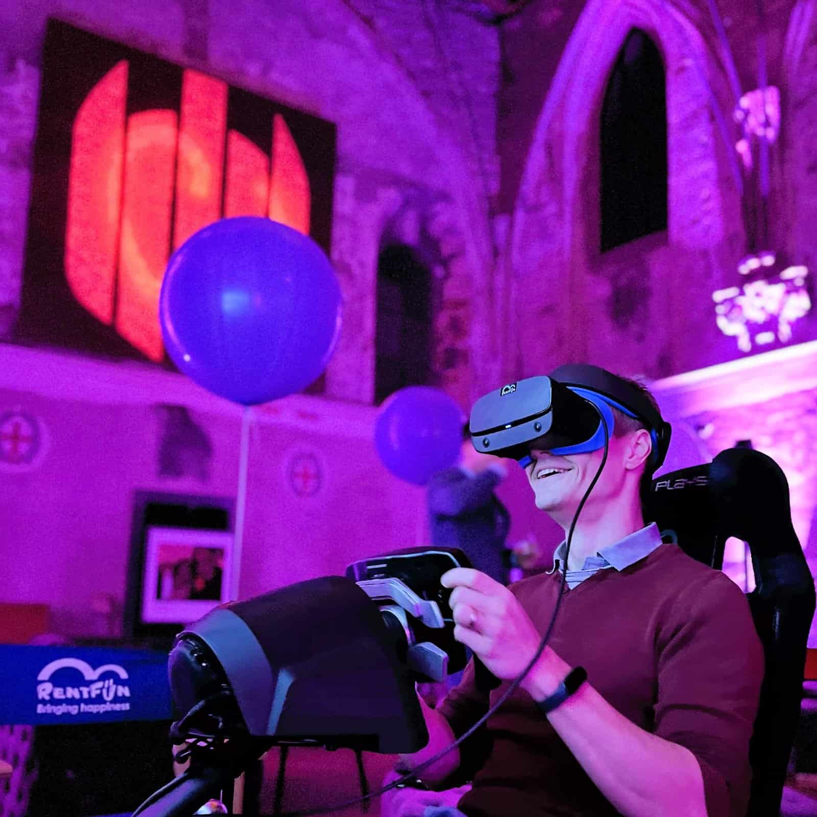 RoarFun Clients SentinelOne Aston Martin F1 team sponsor - Happy person with Formula 1 immersive motion VR simulator at Christmas Party.