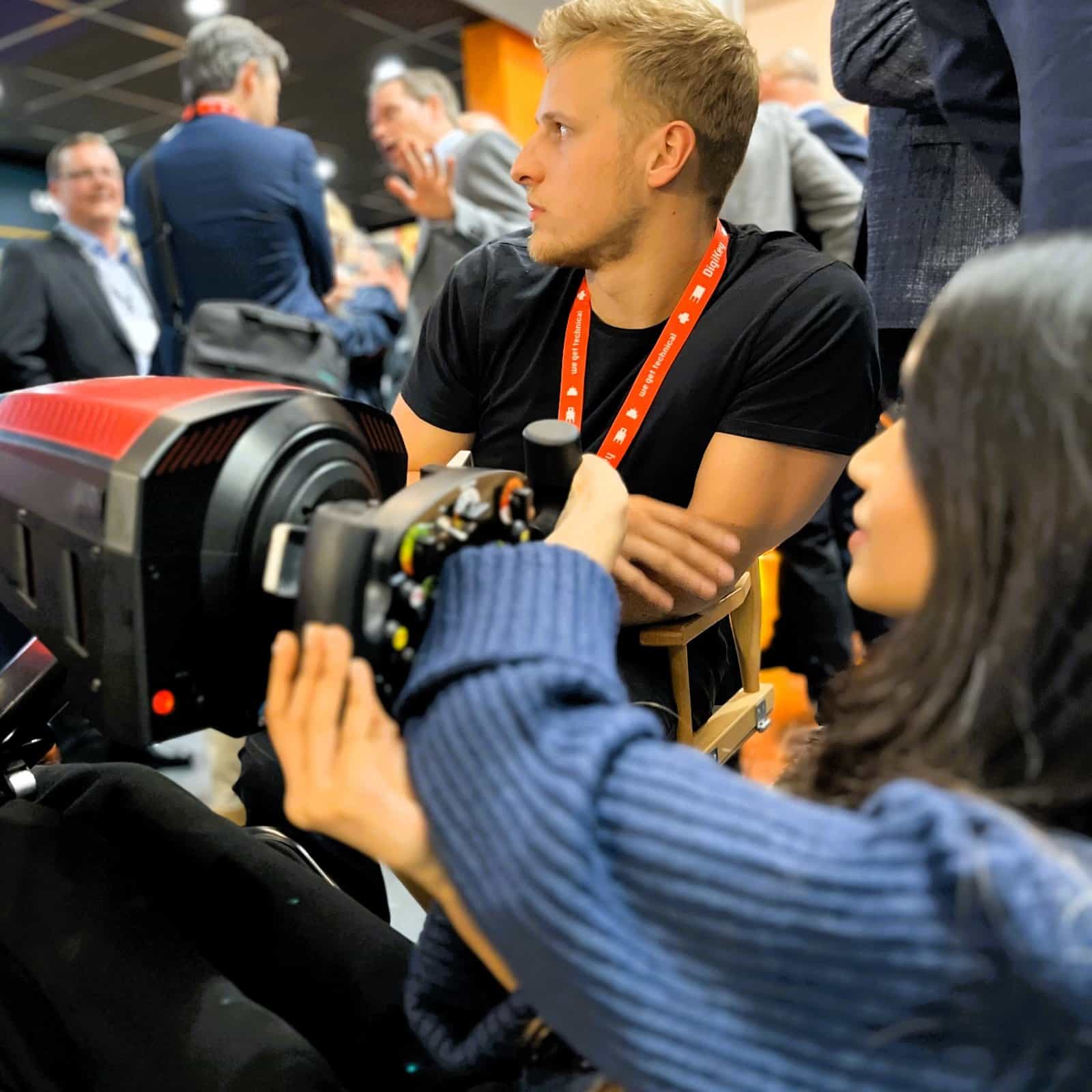 Happy nice girl on a motion racing simulator in Munich expo.